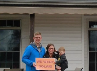Family holding a sign saying We Went Solar