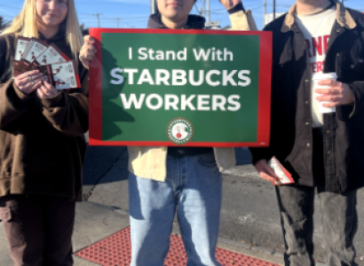 Three young people standing with sign saying I stand with Starbucks workers