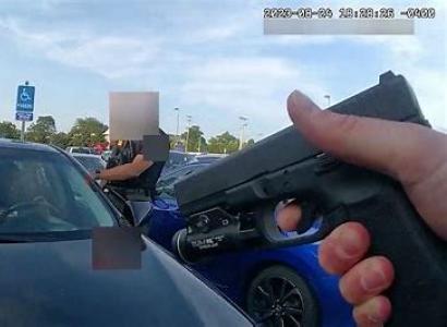 Hand holding a gun at a car