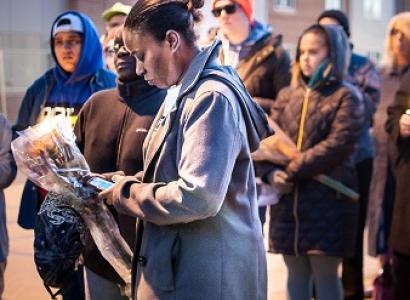 Black woman surrounded by people outside