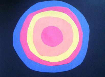 Concentric circles of blue, red, yellow and orange like a sun in the middle of a darker blue background and the word Terrestrials