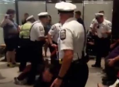 Policeman throwing a woman out of her wheelchair