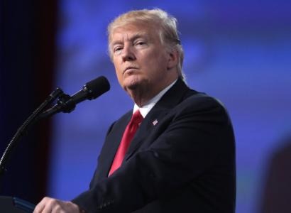 Man with gray hair comb over looking sideways at the camera with slitty eyes