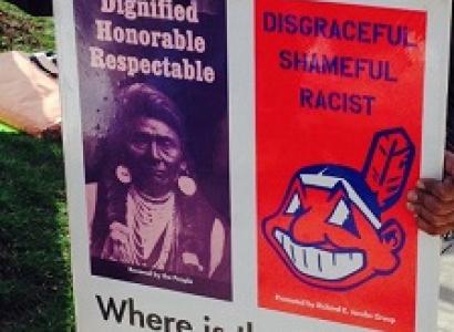 Poster with photo of Native American on left side and big cartoony smily Indian face that is Chief Wahoo the mascot of the Cleveland Indians