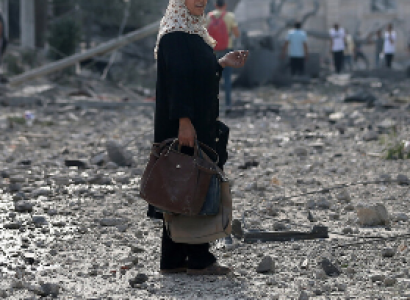 Woman in Gaza street with devastation all around