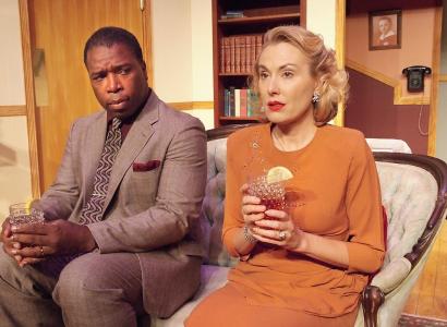 Black man and white woman sitting on a couch