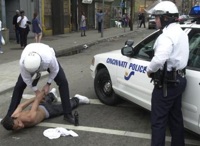Two Cincinnati police with black man on ground in handcuffs