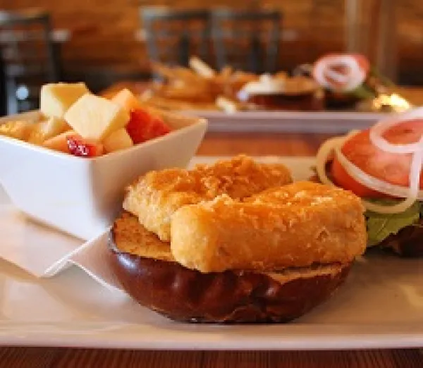 Hamburger-looking bun and food next to lettuce, tomato and other food