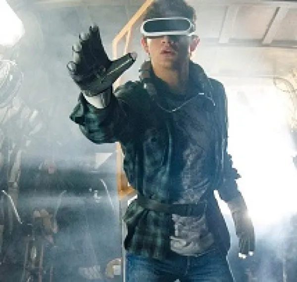 Man with big screen-like goggles like virtual reality headgear with a big glove stretched out on his hand 