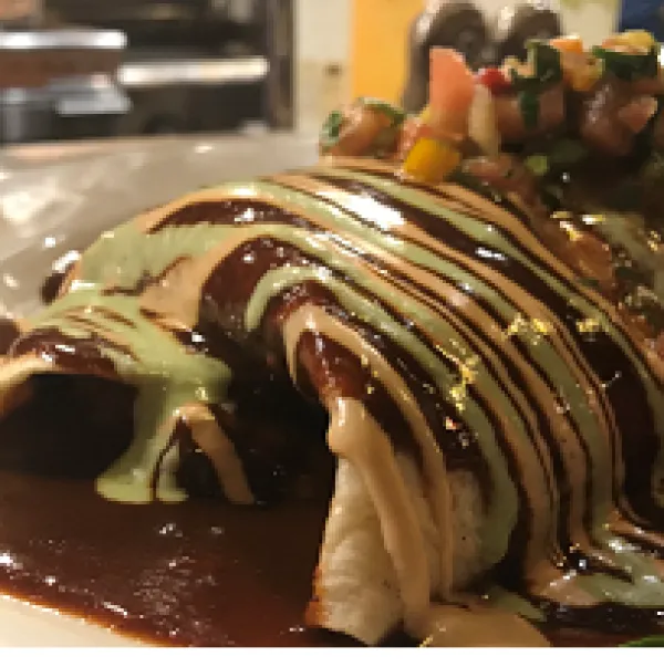 Food on a plate with striped brown and beige sauce on top