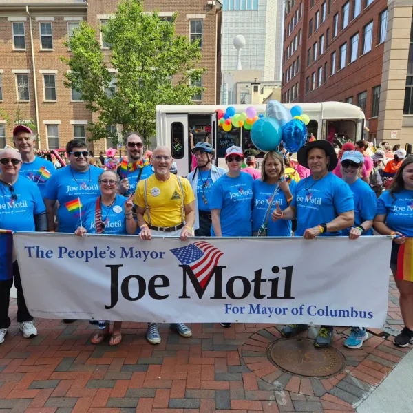 People marching and holding Joe Motil banner