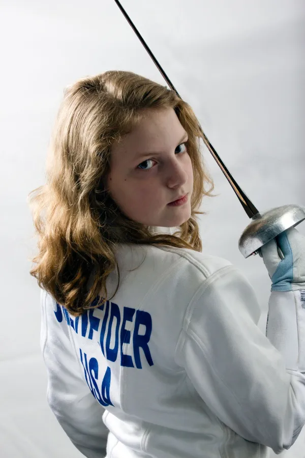 Very young blonde girl looking tough holding a sword