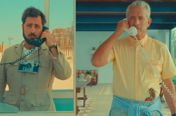 Two men each talking on a phone