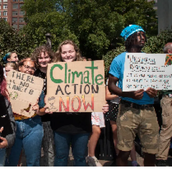 People holding signs at climate strike saying Climate Action Now