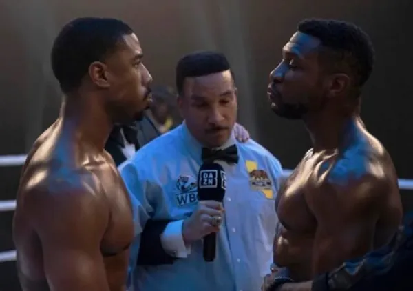 Two fighters facing off in the ring with ref between them