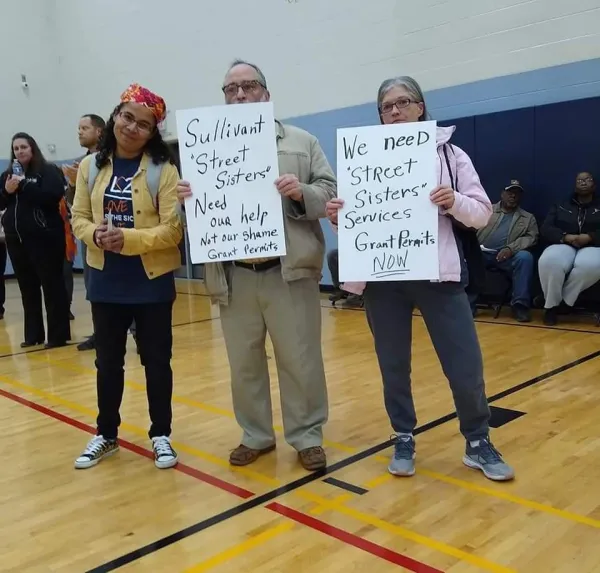 Esther and Gary Witte and Winie Wirth holding signs