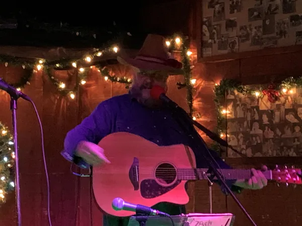 Guy in Cowboy hat playing a guitar