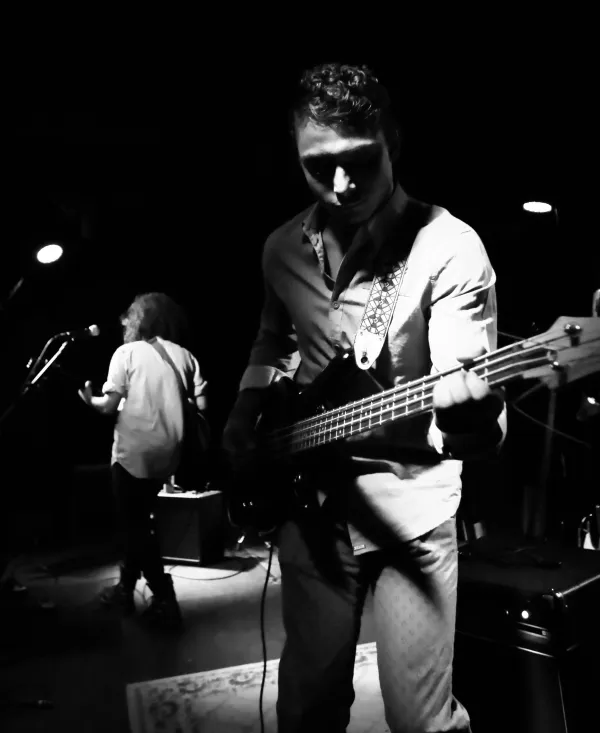 Black/white photo of guy playing a guitar in a band
