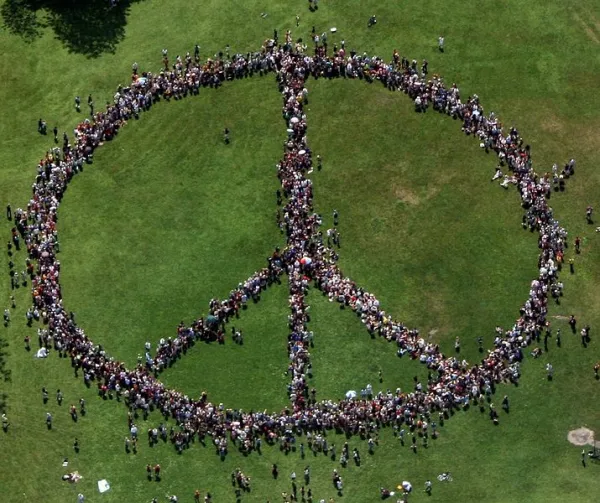 People standing as a peace sign from a distance