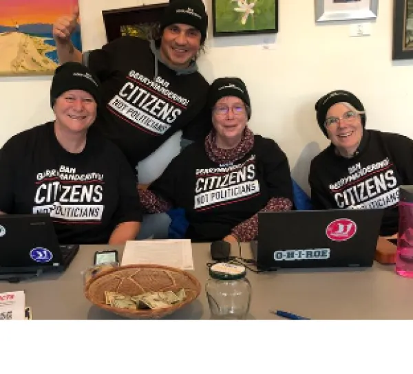 Four people posing at a desk
