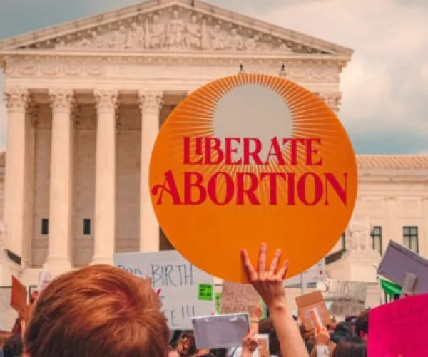 Sign in front of government building saying Liberate Abortion