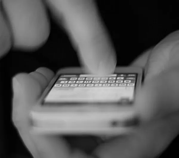 Hand typing onto a cellphone