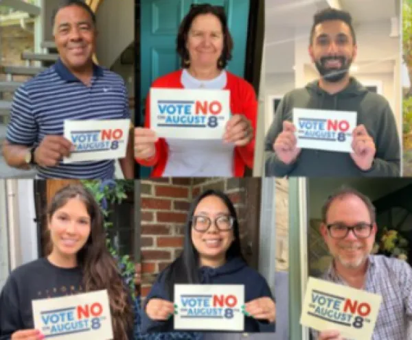 People holding signs saying Vote No on Issue One