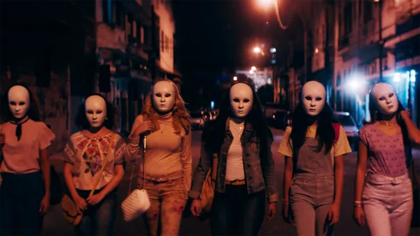 Women walking at night wearing masks