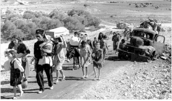 Families walking down a road with all their belongings
