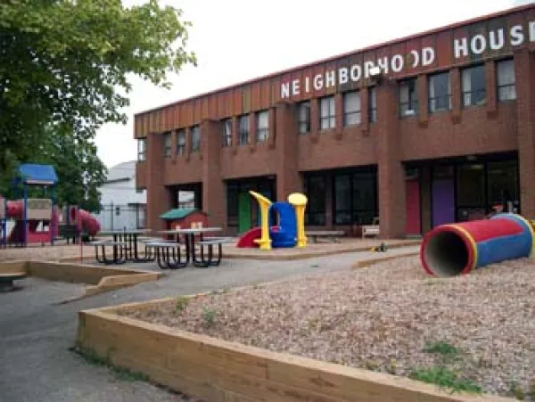 A brick building with words Neighborhood House on it