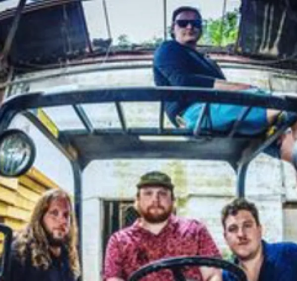 The four men in the band posing 