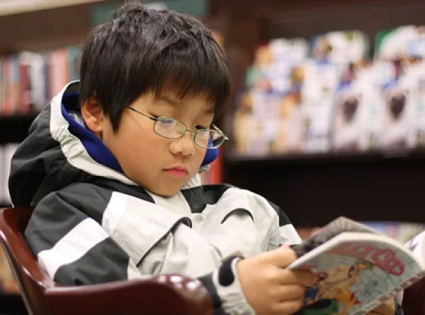 An asian boy reading GRAPHiC N0VEL in a Barnes & Noble bookstore in West Hartford, Connecticut