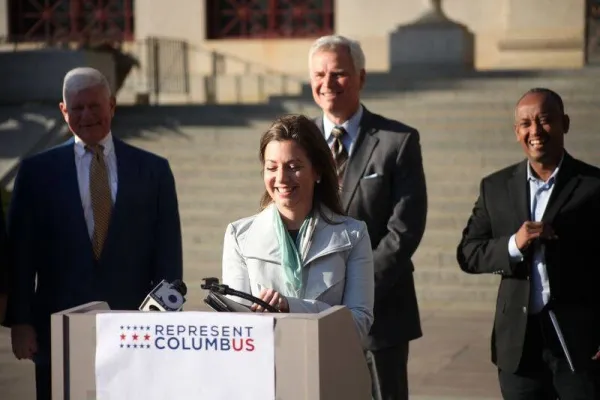 Woman speaking at podium outside at press conference