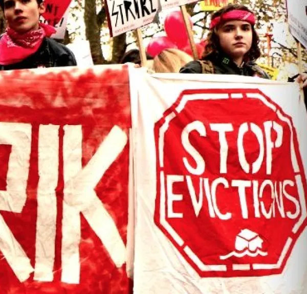People holding signs saying Stop Evictions