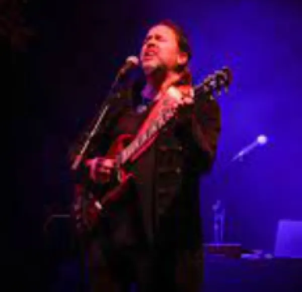 Guy singing with guitar on stage