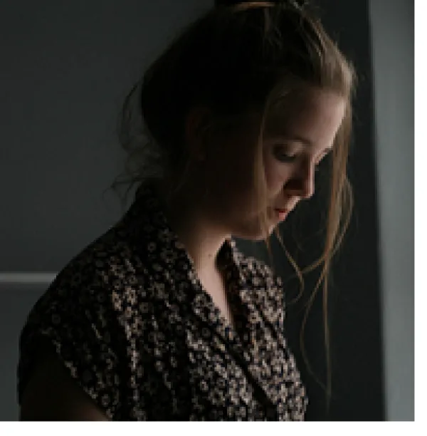 Young white woman in a side view as she looks down