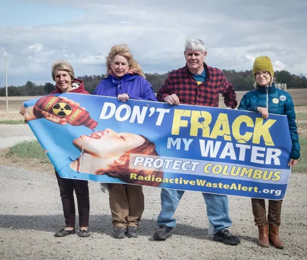 Four people holding a Don't Frack My Water sign