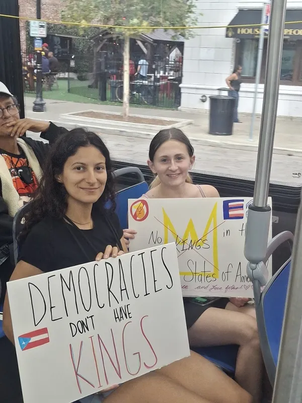 Young women with signs on a bus