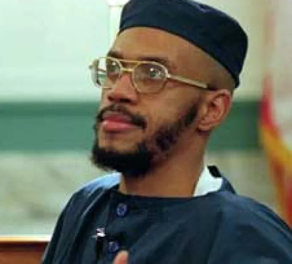 Black man  with wire-rimmed glasses and a mustache and beard